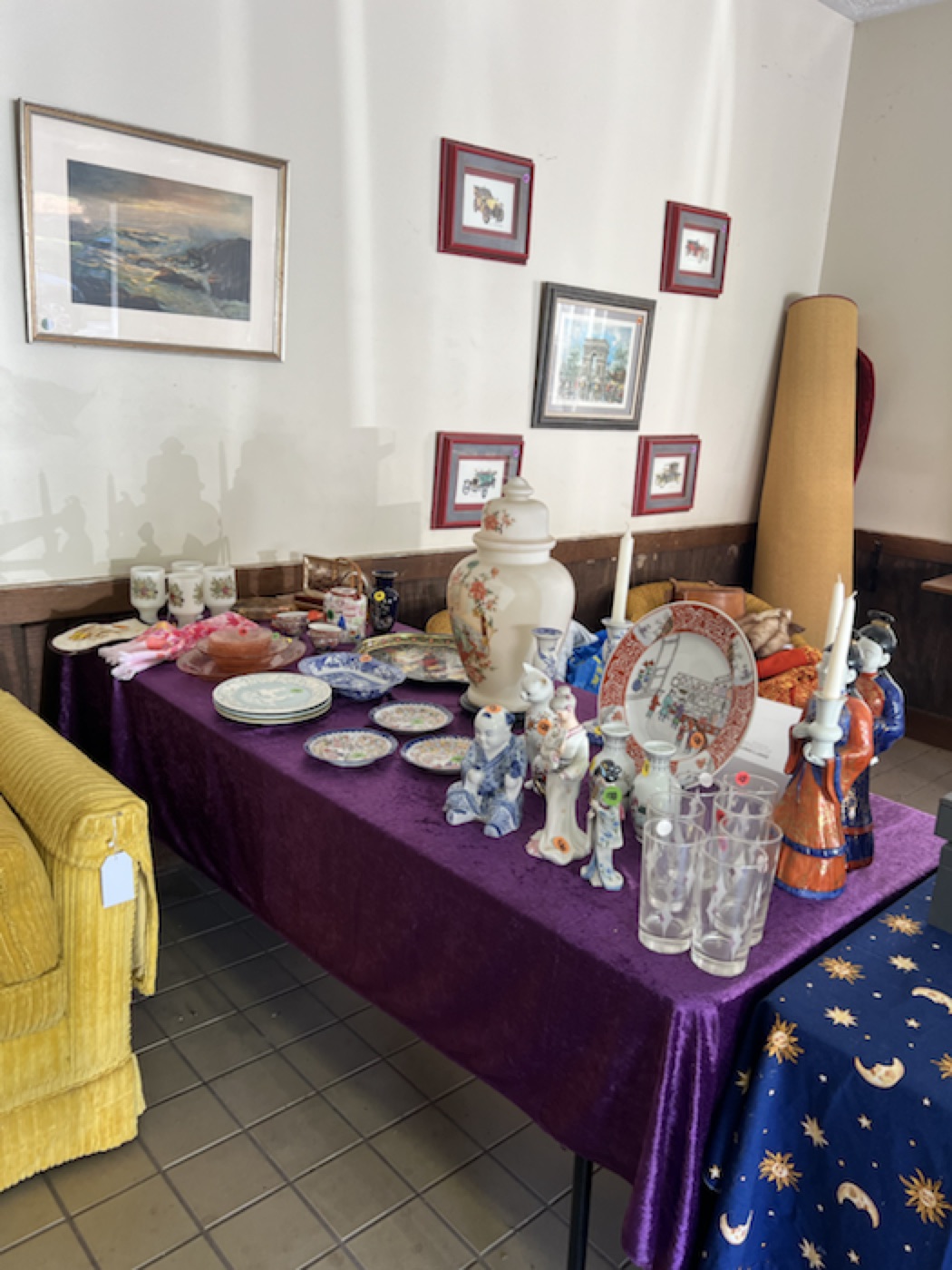 Porcelain, silver, and decorative objects arranged on plum velvet