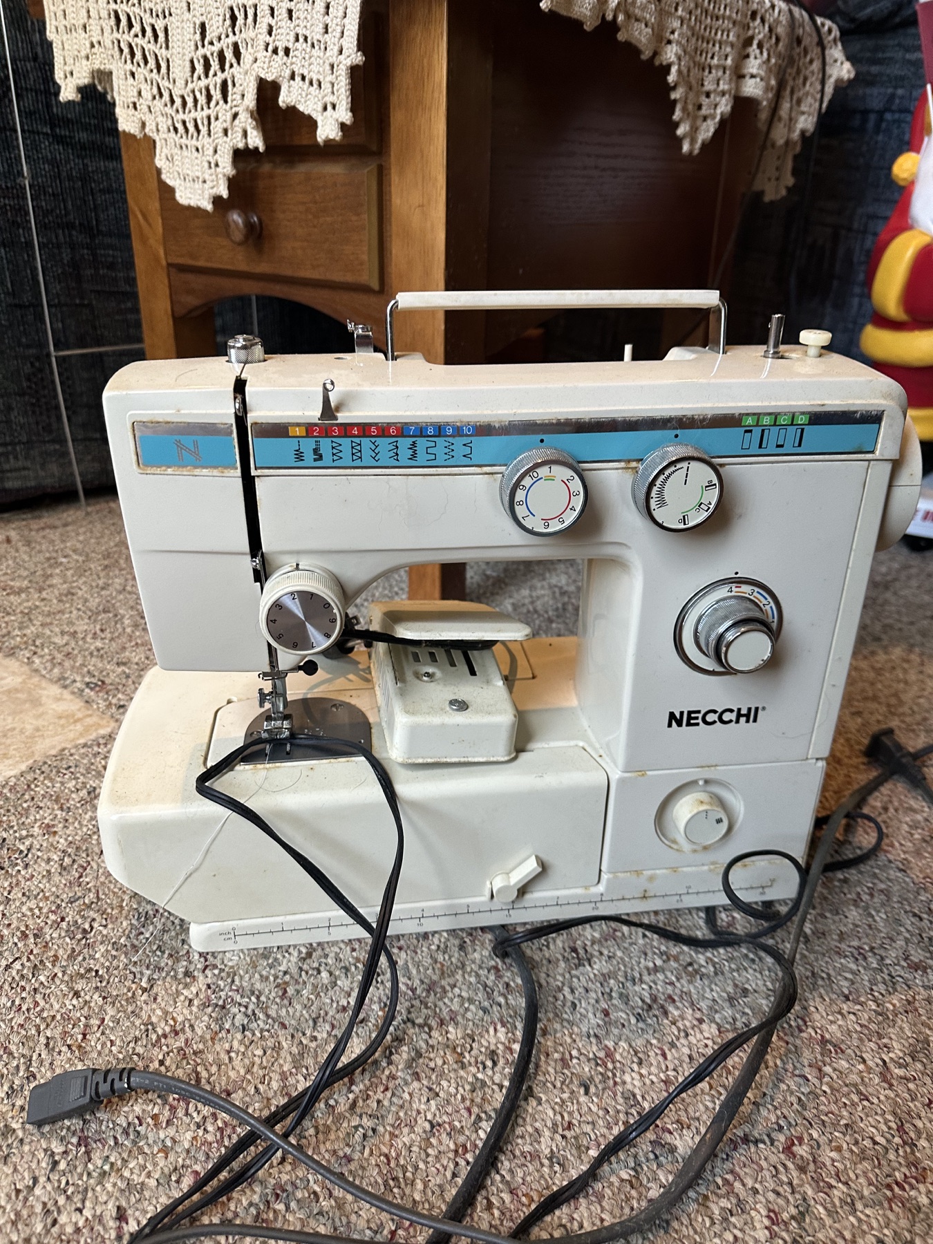 Vintage white and blue Necchi sewing machine with control dials