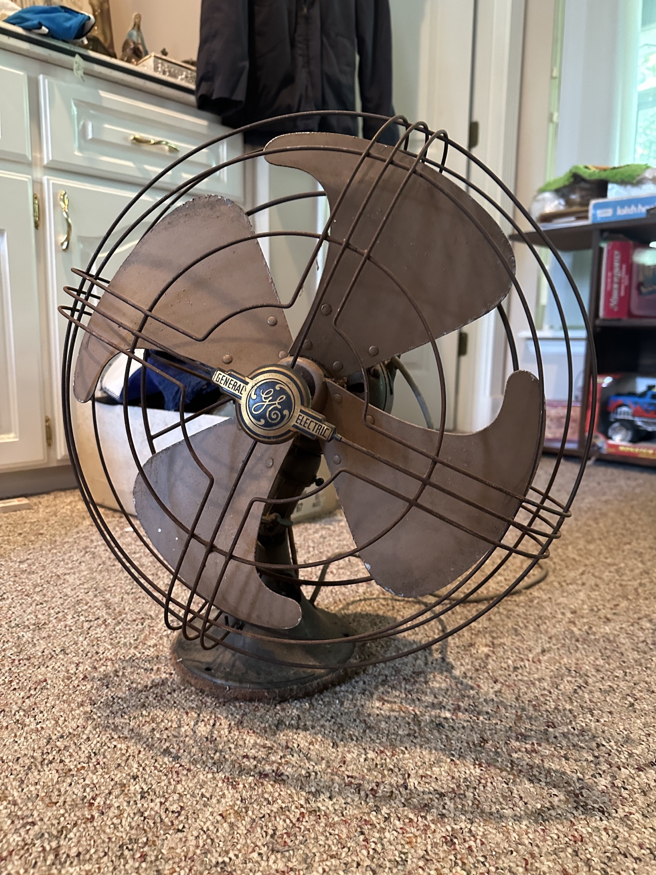 Vintage General Electric metal desk fan with three broad blades and wire guard