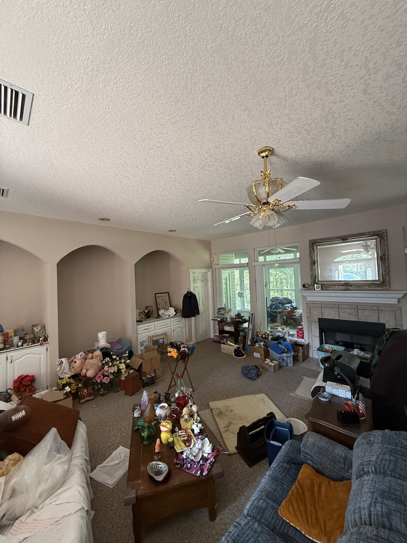 Wide fireplace room filled with furniture and collected objects